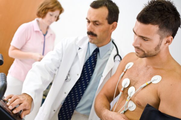 medico prepara paziente per eseguire elettrocardiogramma da sforzo